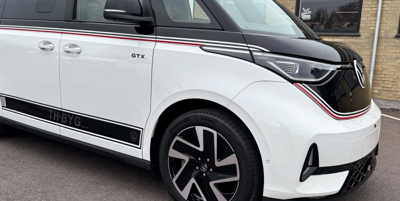 Denne VW ID. Buzz GTX har fået et markant og sporty udtryk med sort delindpakning af bilens øverste del kombineret med specialdesignet foliedekoration. De gennemgående striber i sort, hvid og rød følger bilens linjer fra front til bag og binder designet sammen, mens den sorte overdel giver bilen et mere eksklusivt og karakterfuldt udtryk. Opgaven omfattede: Delindpakning · Specialdesign · Foliedekoration